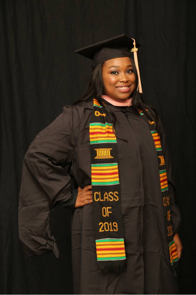 masters student posing in her cap and gown